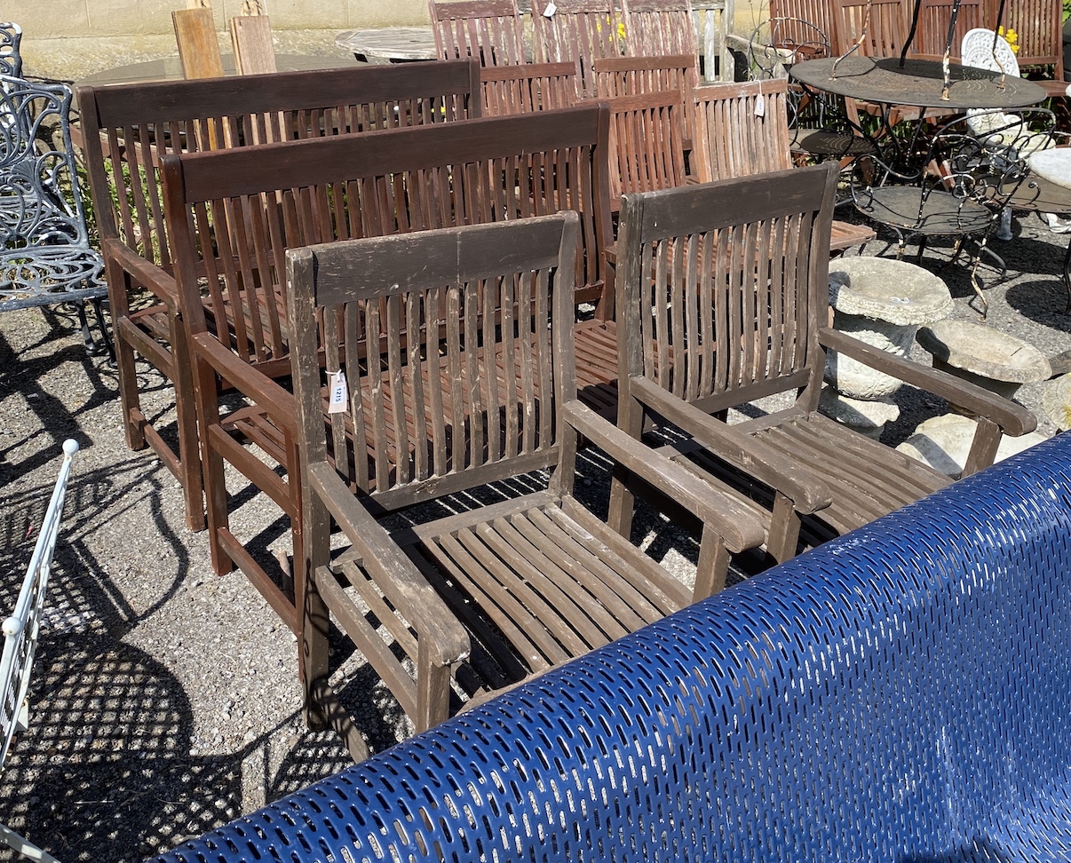 A pair of stained teak garden benches, width 121cm, height 99cm, and a pair of matching elbow chairs